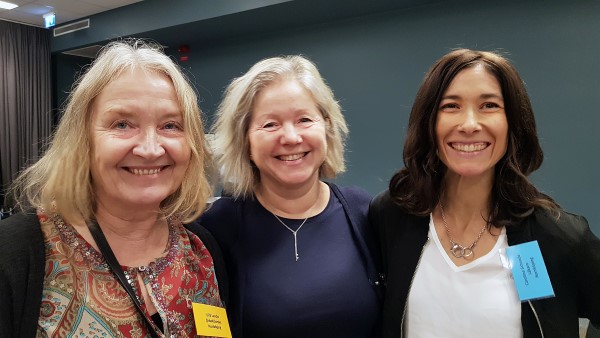Tre leende kvinnor på hjärtkonferens.
