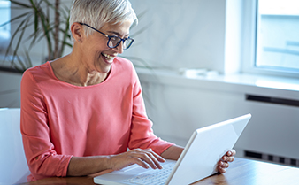 Leende kvinna vid laptop