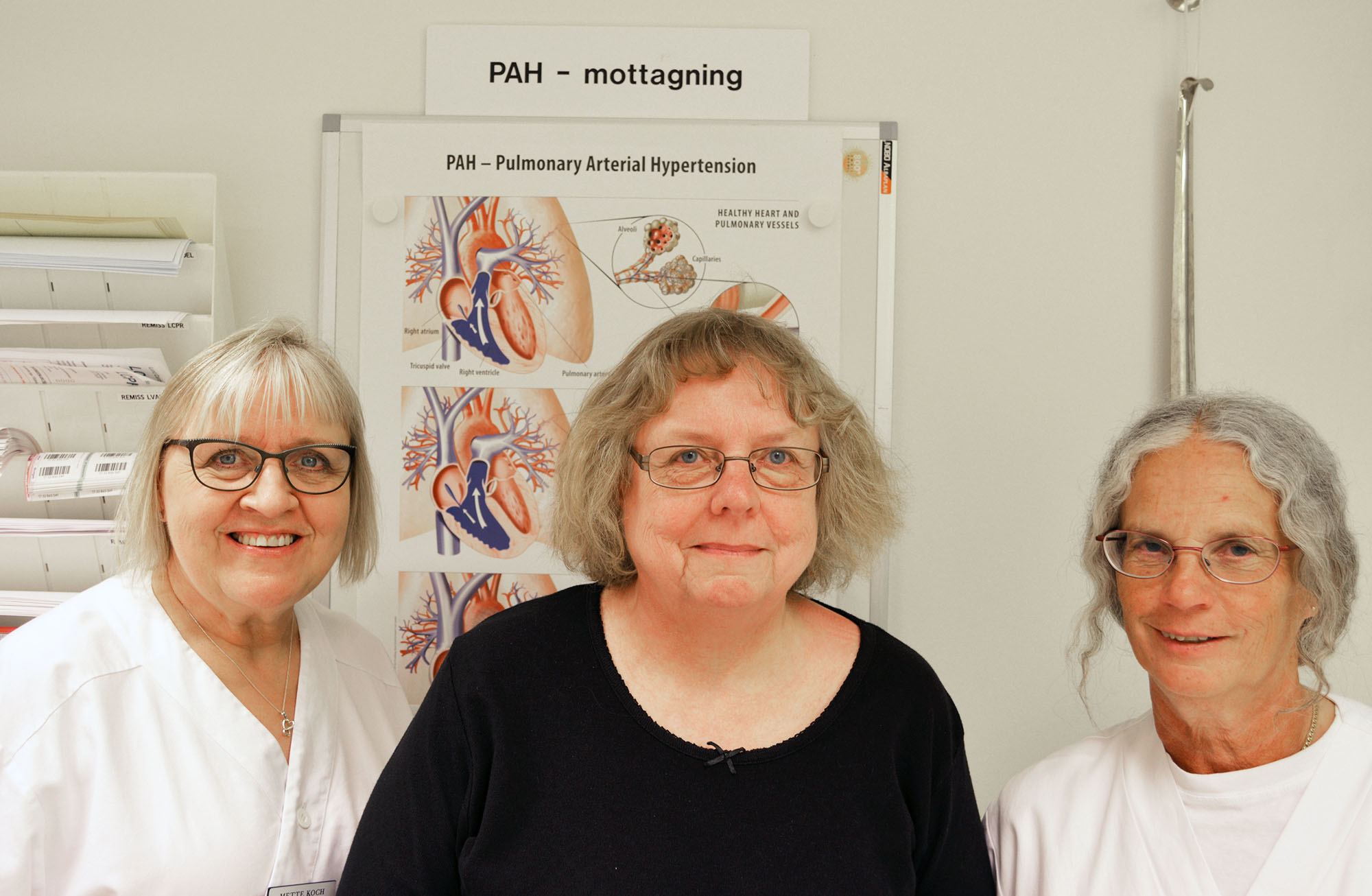Tre sjuksköterskor framför en plansch med information om PAH.